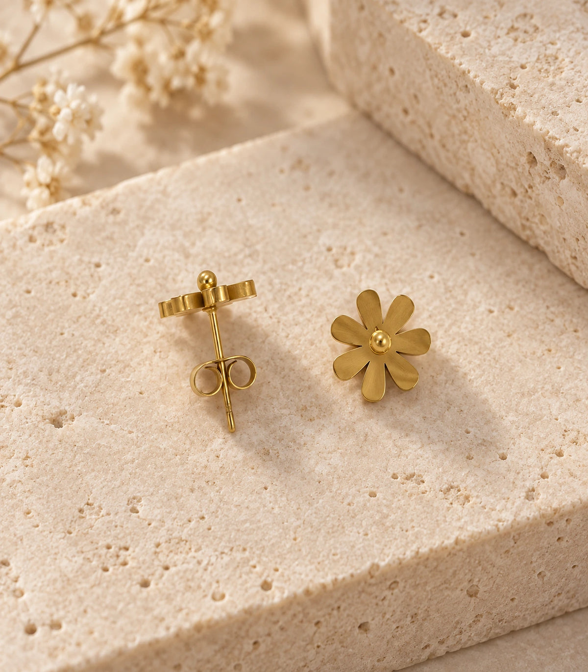 JIMIKI Satin Gold Seven-Petal Daisy Stud Earrings, pair arranged on a pale textured surface with front and back visible #color_satin gold