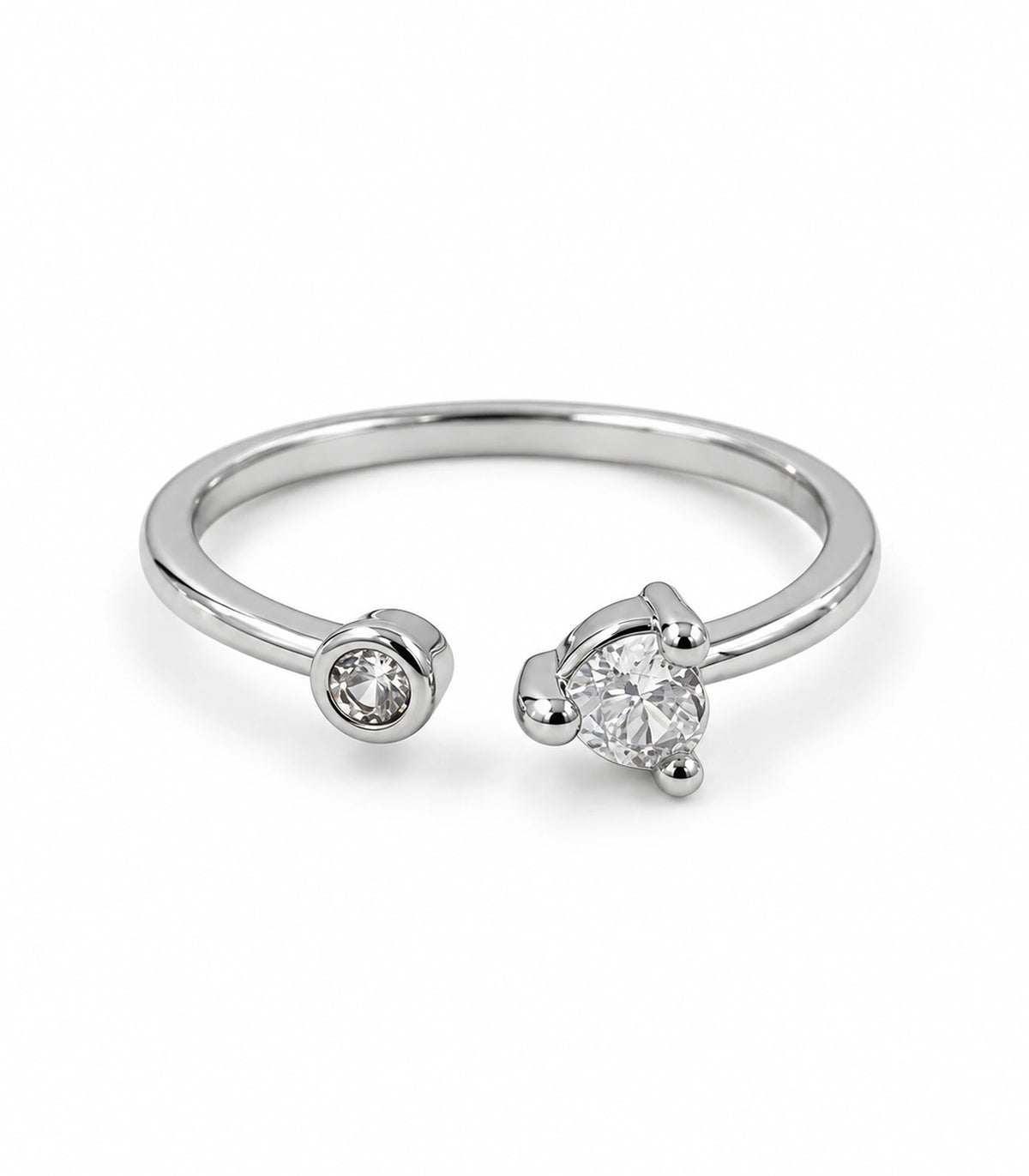 Silver-tone asymmetric open ring with a small bezel-set and larger three-prong clear round accent on white