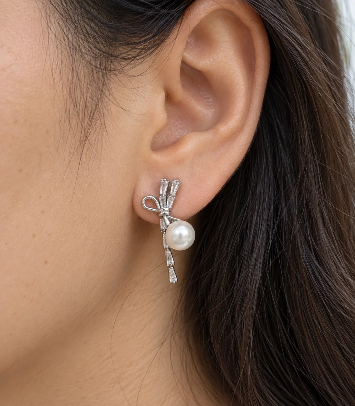 JIMIKI Silver Baguette Bow Pearl Drop Earrings - worn close-up showing earring detail #color_silver