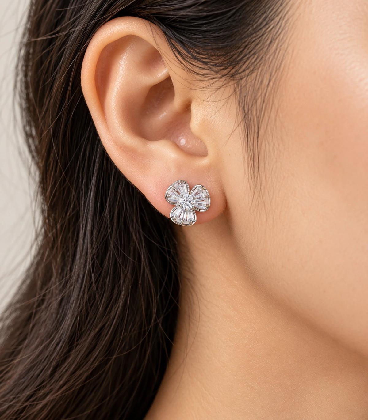 Alternate worn view of the silver-tone three-petal flower stud earring
