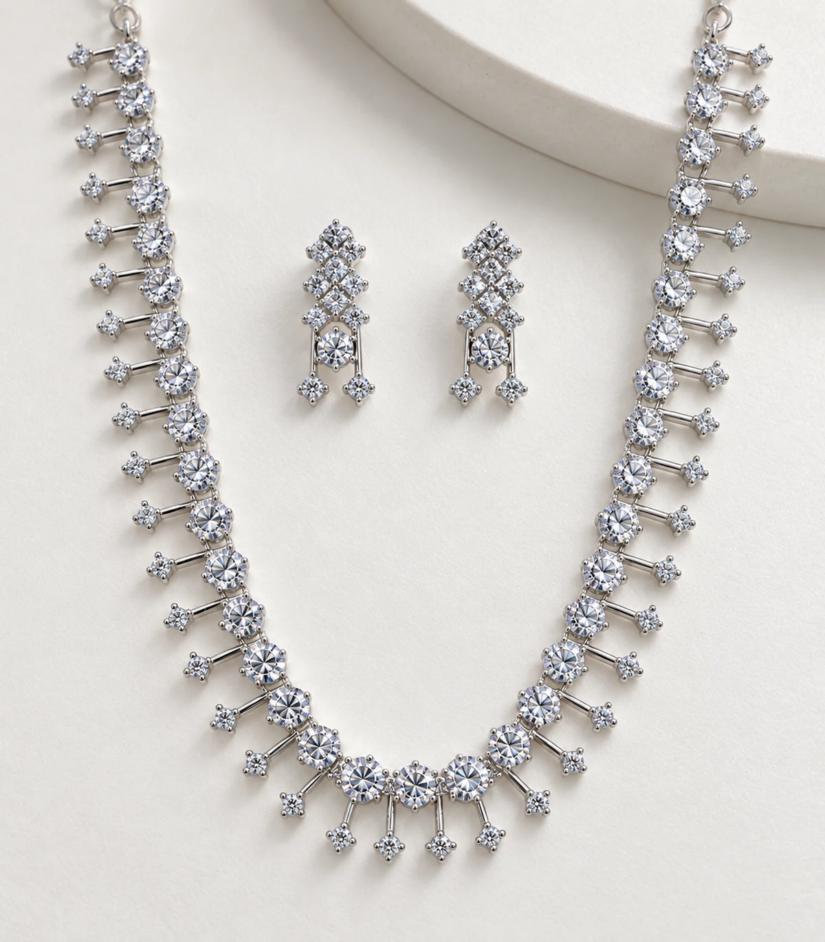 Detail of clear crystal necklace and matching earrings on a pale display surface