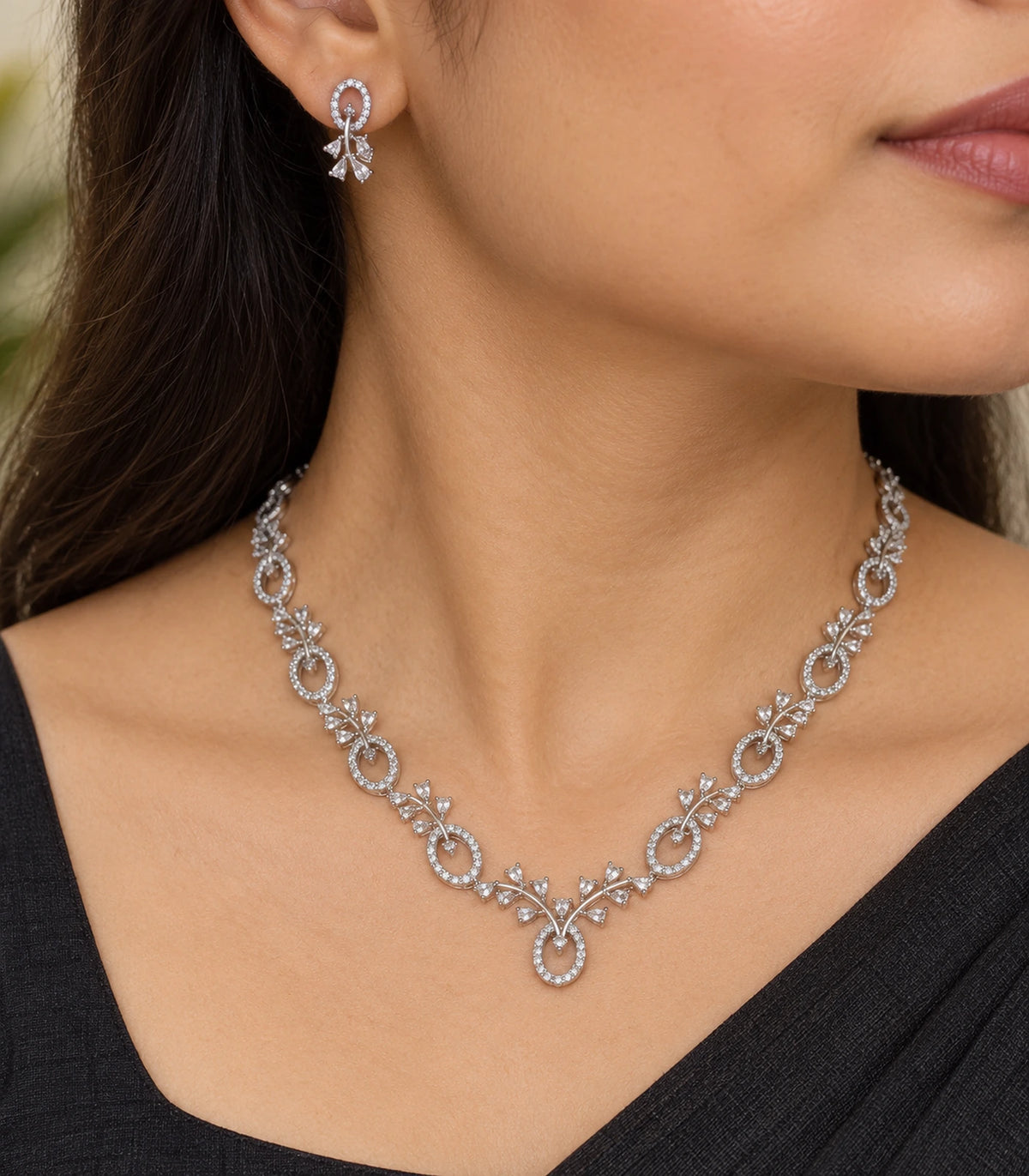 Closeup of Silver Clear Floral Drop Crystal Necklace Set worn with a black outfit