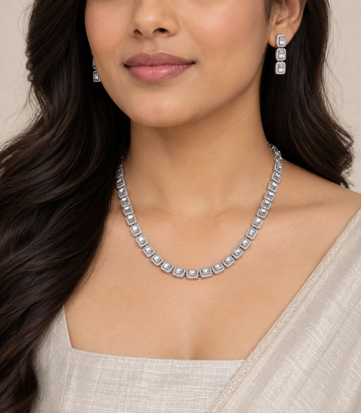 Silver-tone clear linked halo necklace and matching drop earrings worn with an ivory outfit