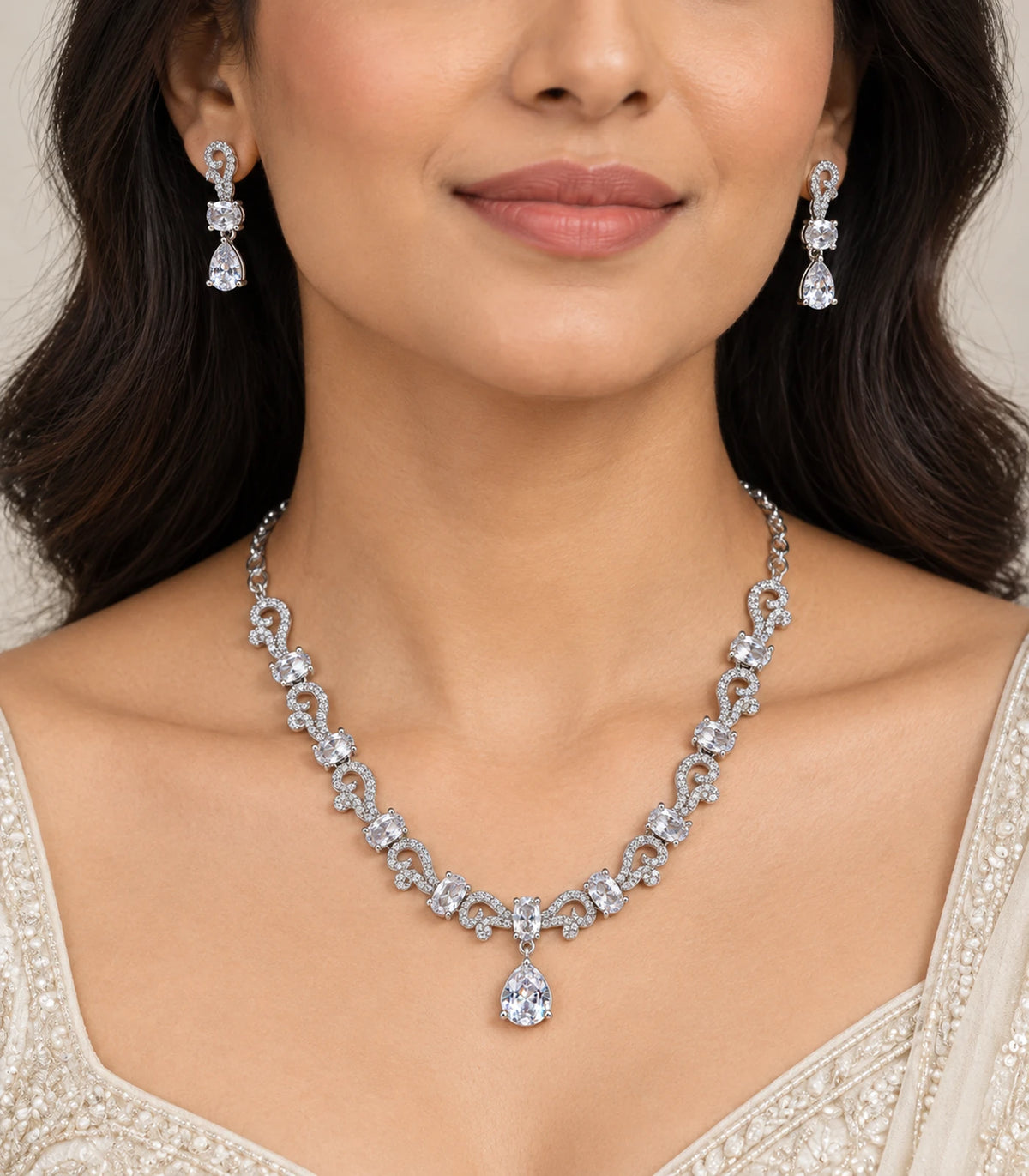 Silver clear paisley necklace and matching teardrop drop earrings worn with an ivory outfit