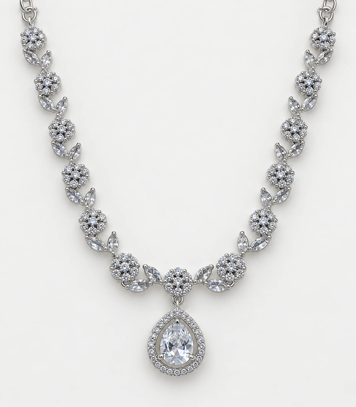 Close view of silver-tone floral links, clear stones and teardrop necklace pendant