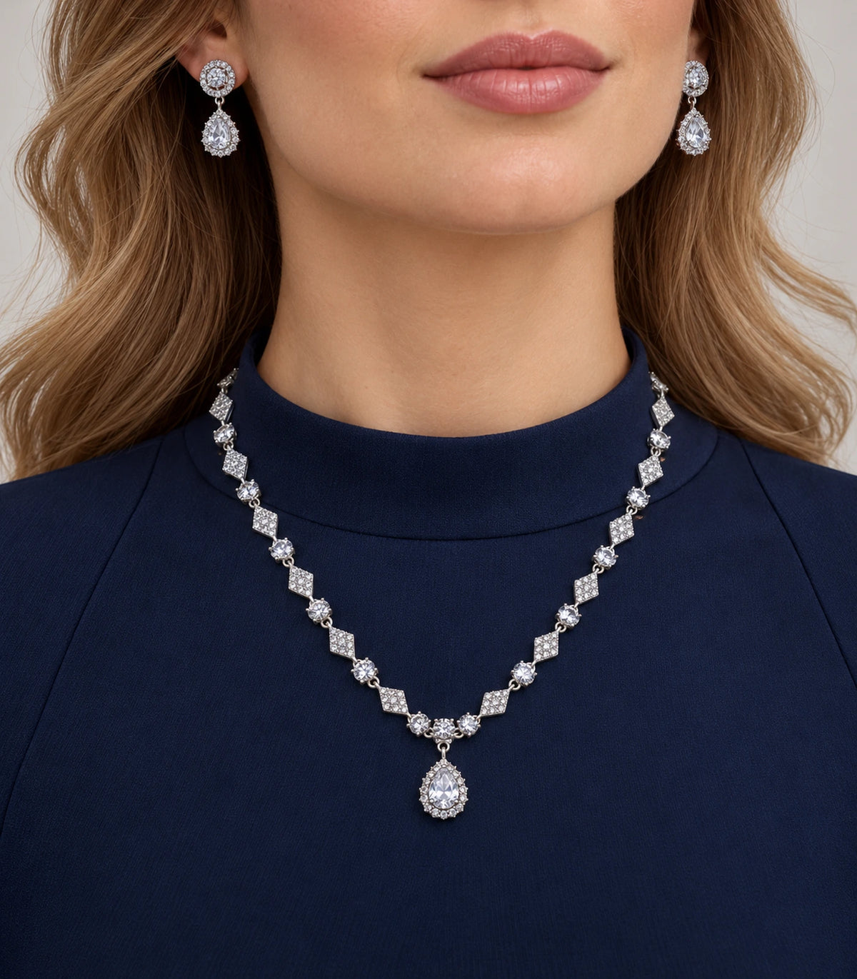 Silver-tone clear necklace and matching earrings worn with a navy outfit