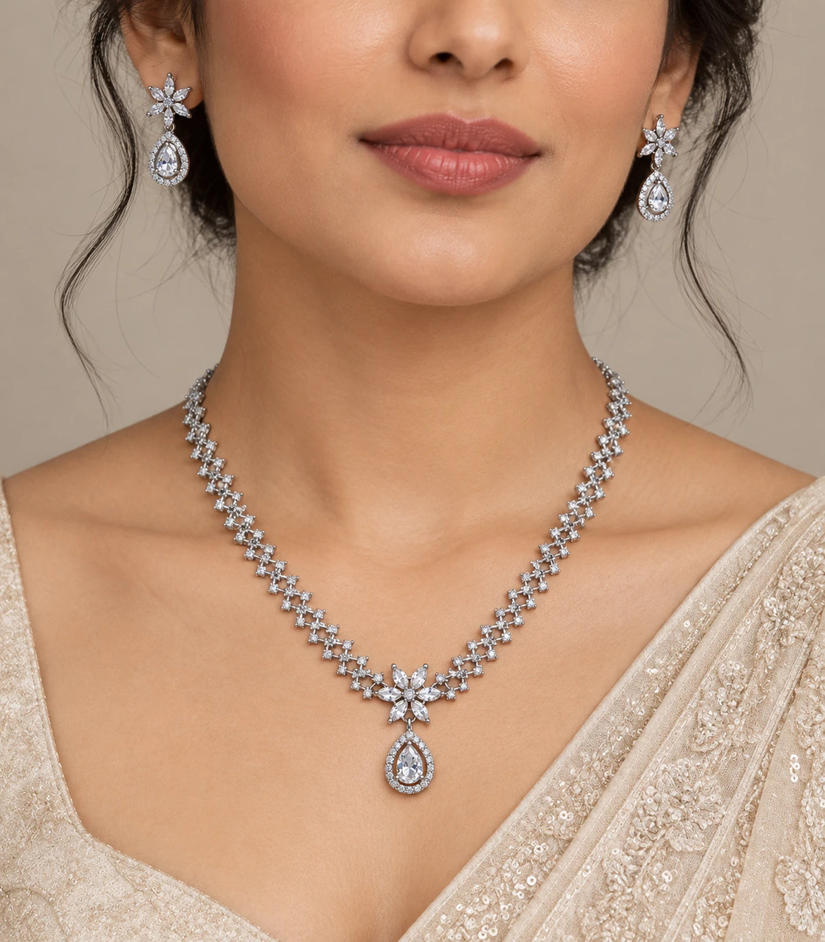 Silver clear star teardrop necklace and matching earrings worn with an ivory outfit