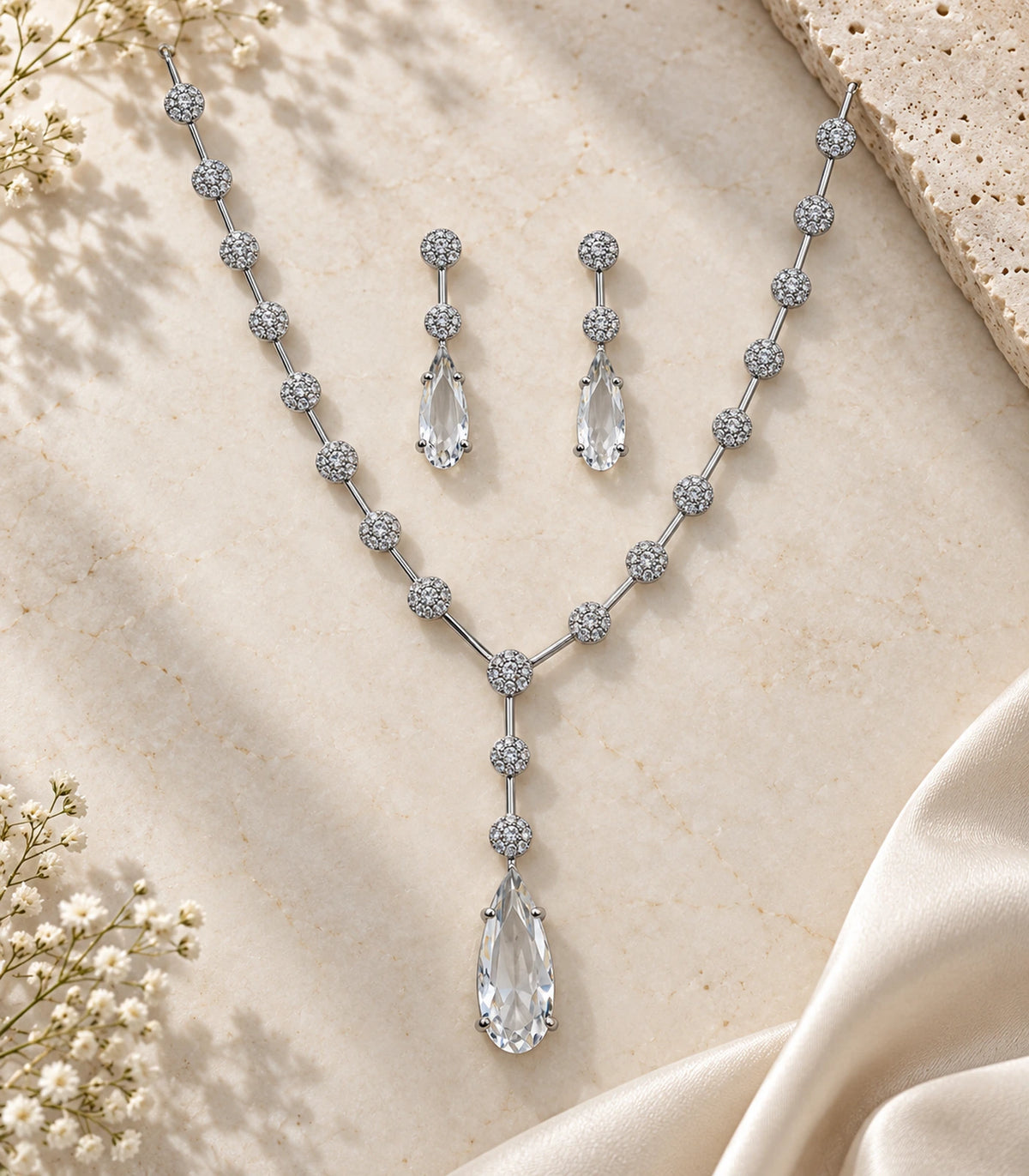 Silver Clear Y-Drop Crystal Necklace Set with both earrings styled on a pale surface