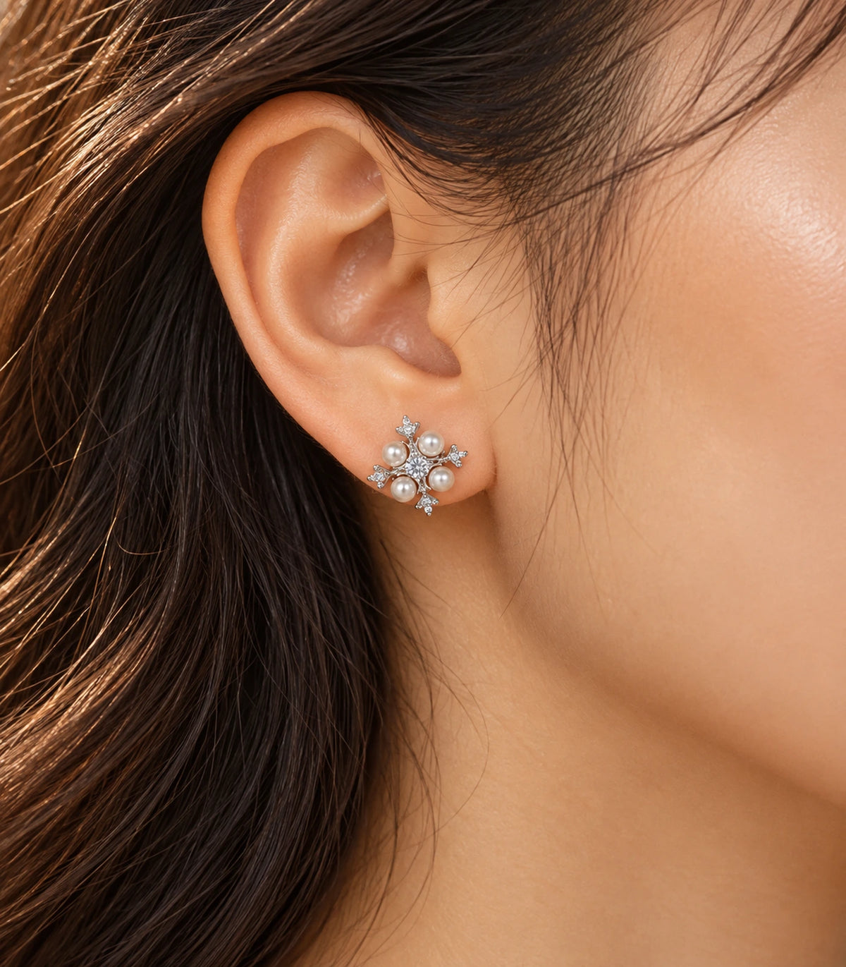 JIMIKI silver crystal pearl snowflake stud earrings, shown worn in warm editorial lighting #color_silver