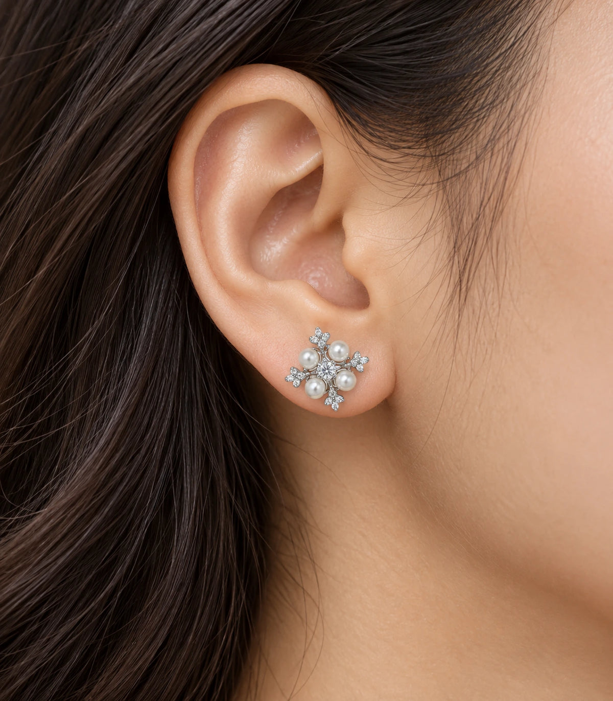 JIMIKI silver crystal pearl snowflake stud earrings, shown worn on the ear #color_silver