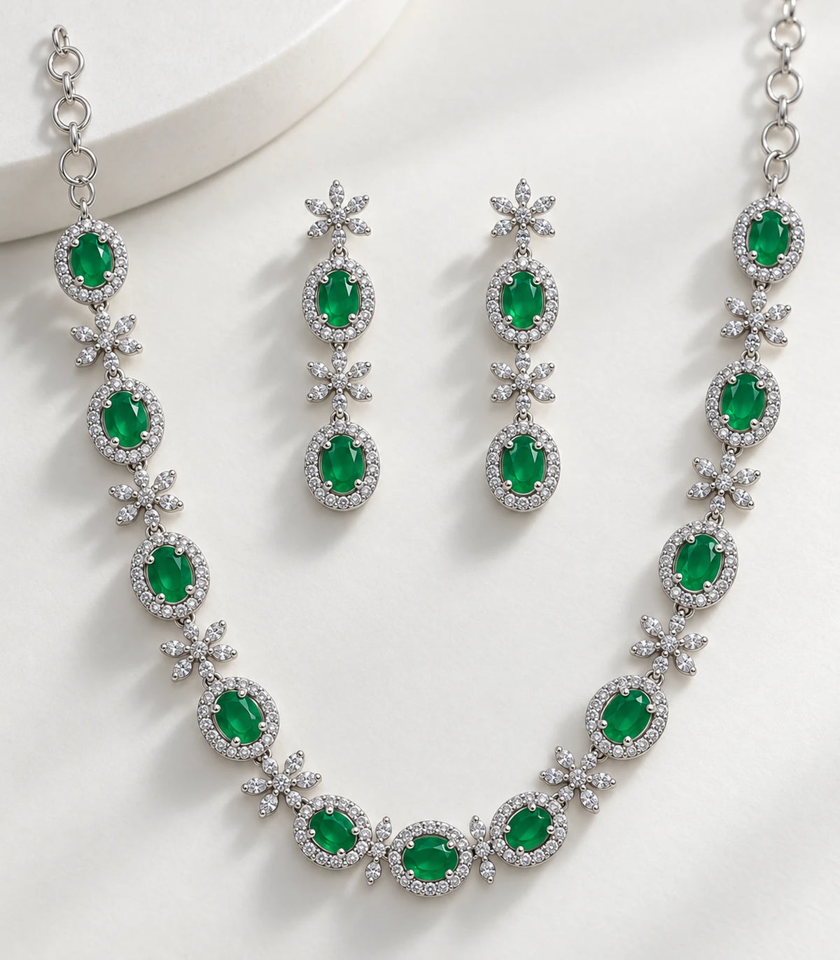 Close view of the green oval settings, clear floral accents and matching earrings