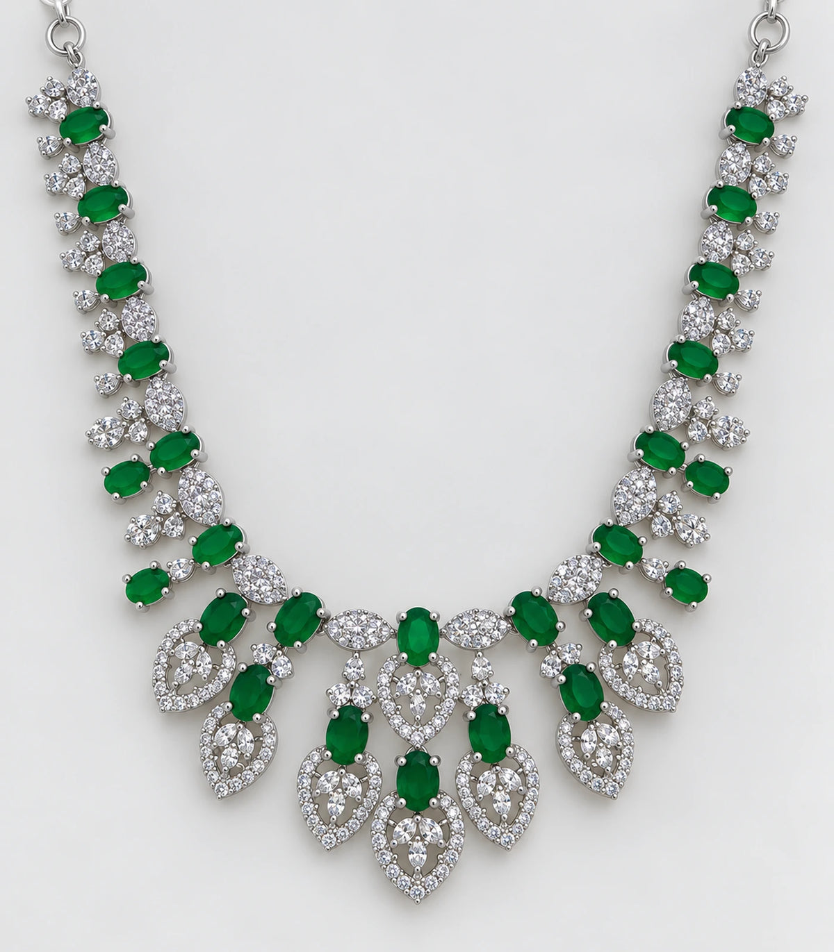 Close detail of the emerald-green necklace and clear teardrop-shaped motifs