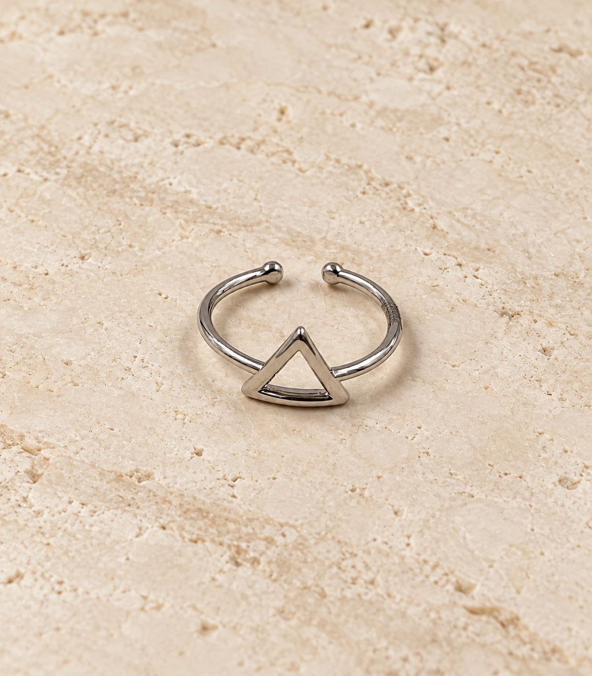 Silver Hollow Triangle Open Ring on a textured surface