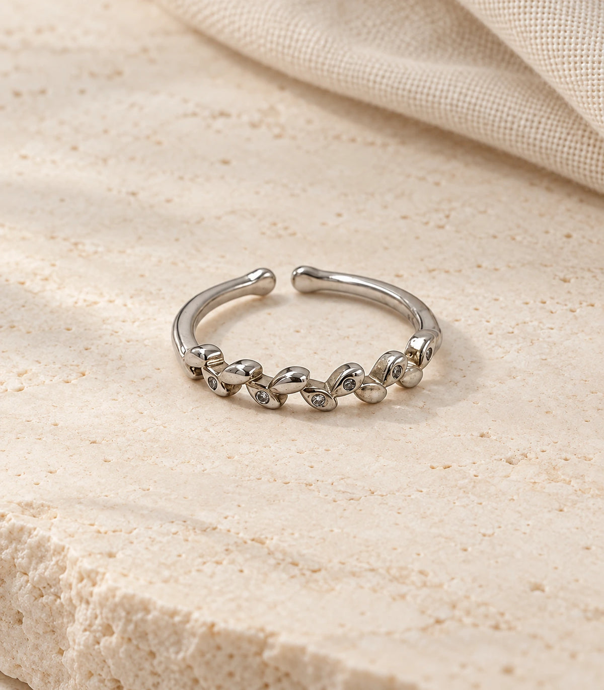 JIMIKI Silver Linked Leaf Crystal Ring in Silver - editorial flatlay #color_silver