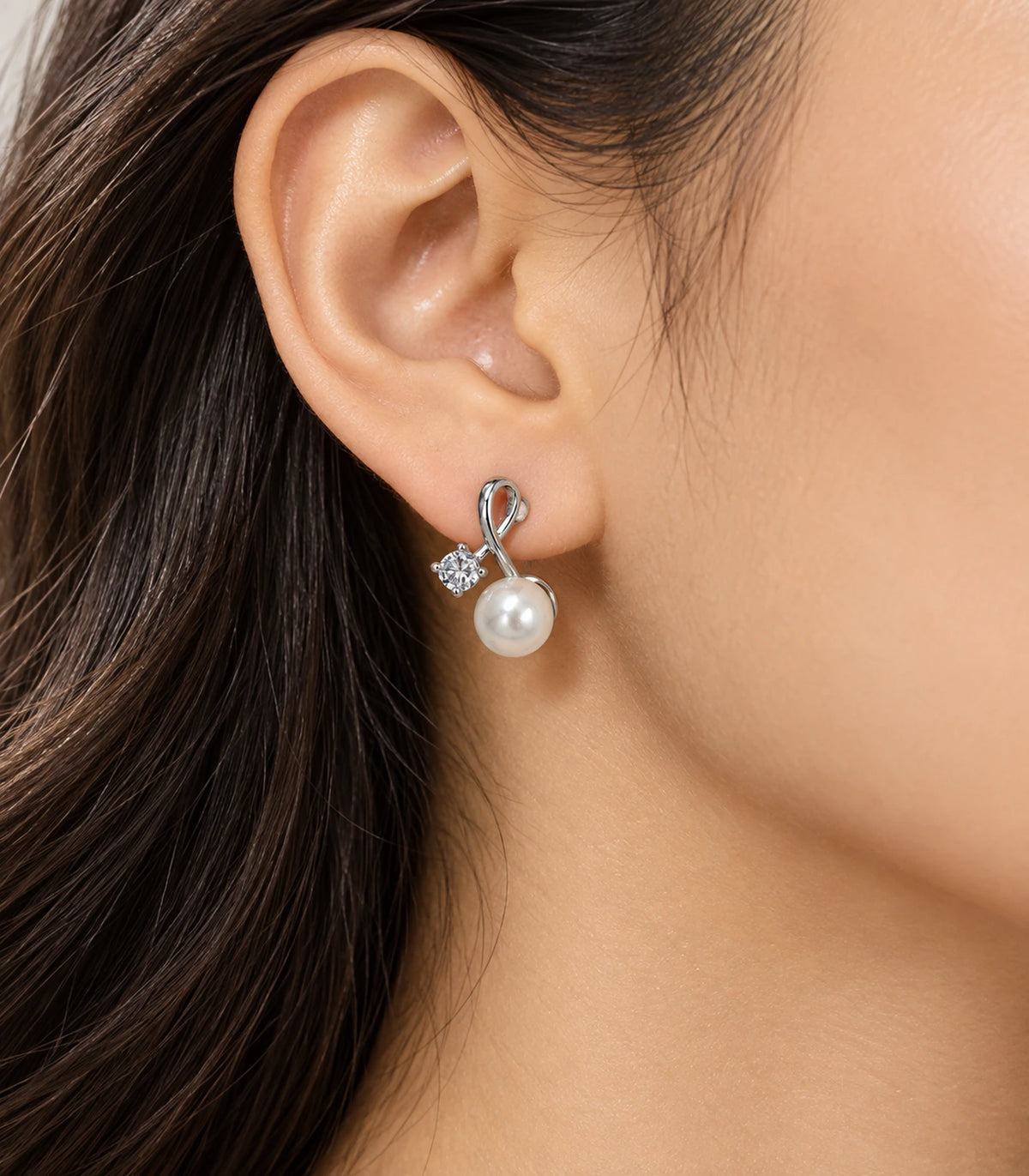 Editorial ear profile wearing the silver-tone loop earring with clear accent and white pearl-style drop