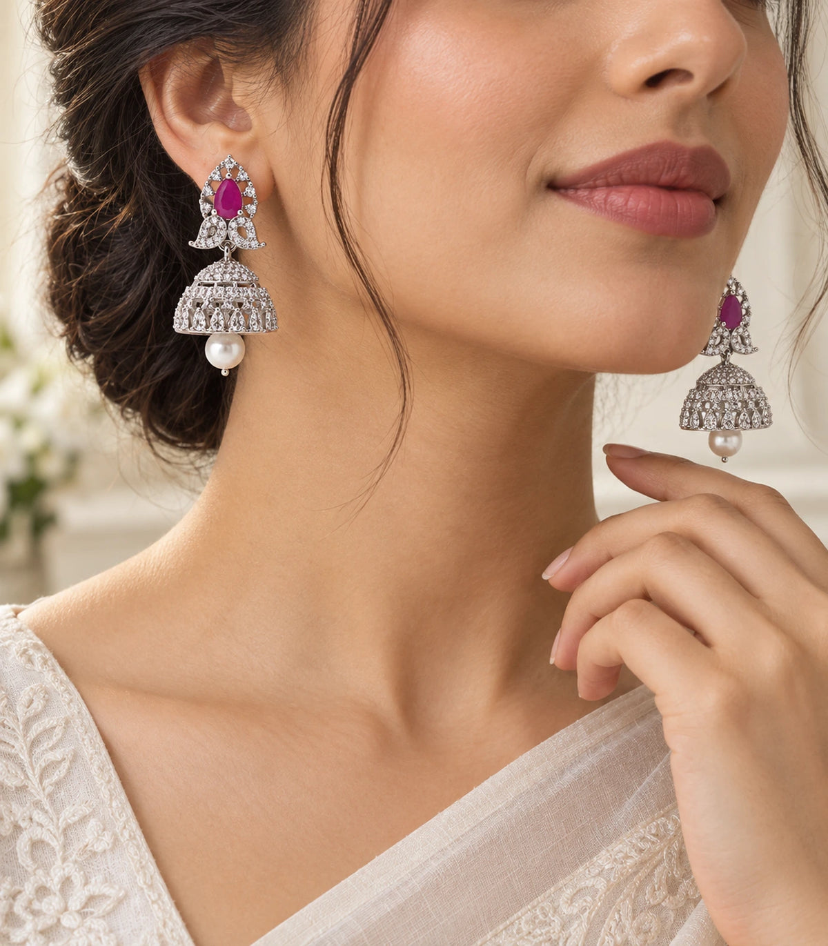 Silver-tone magenta butterfly pearl-style jhumka pair shown worn in an editorial composition