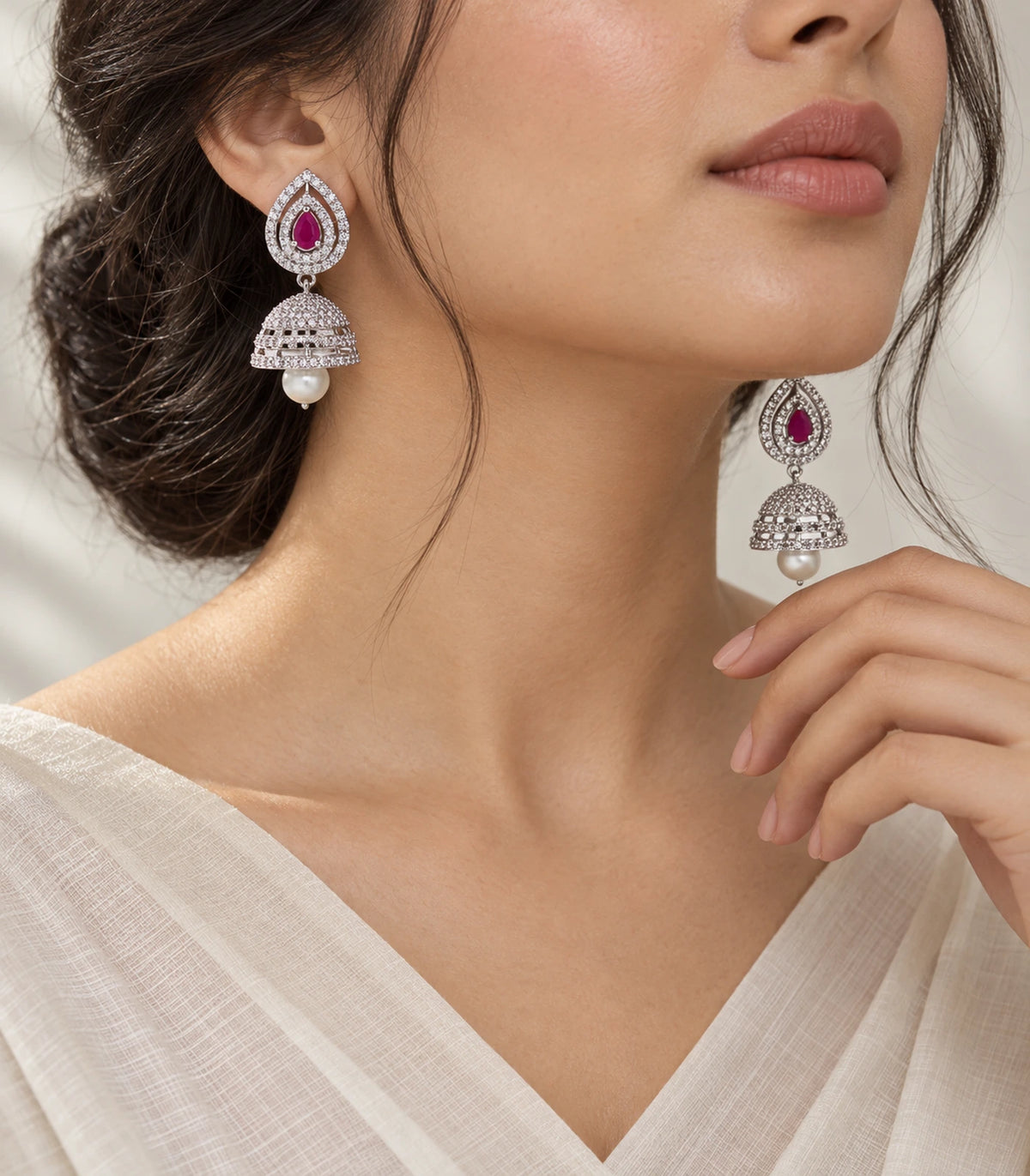 Magenta double halo jhumka earrings styled with an ivory outfit in an editorial model view