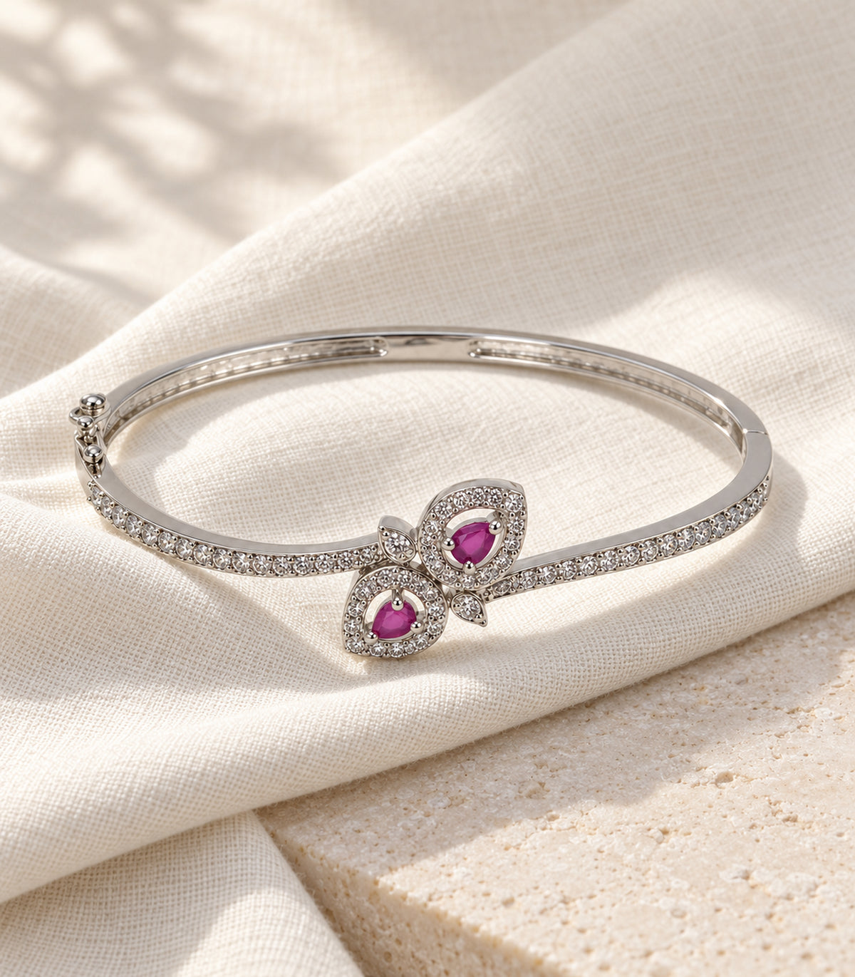 One complete silver magenta double leaf hinged bangle on ivory linen and pale stone
