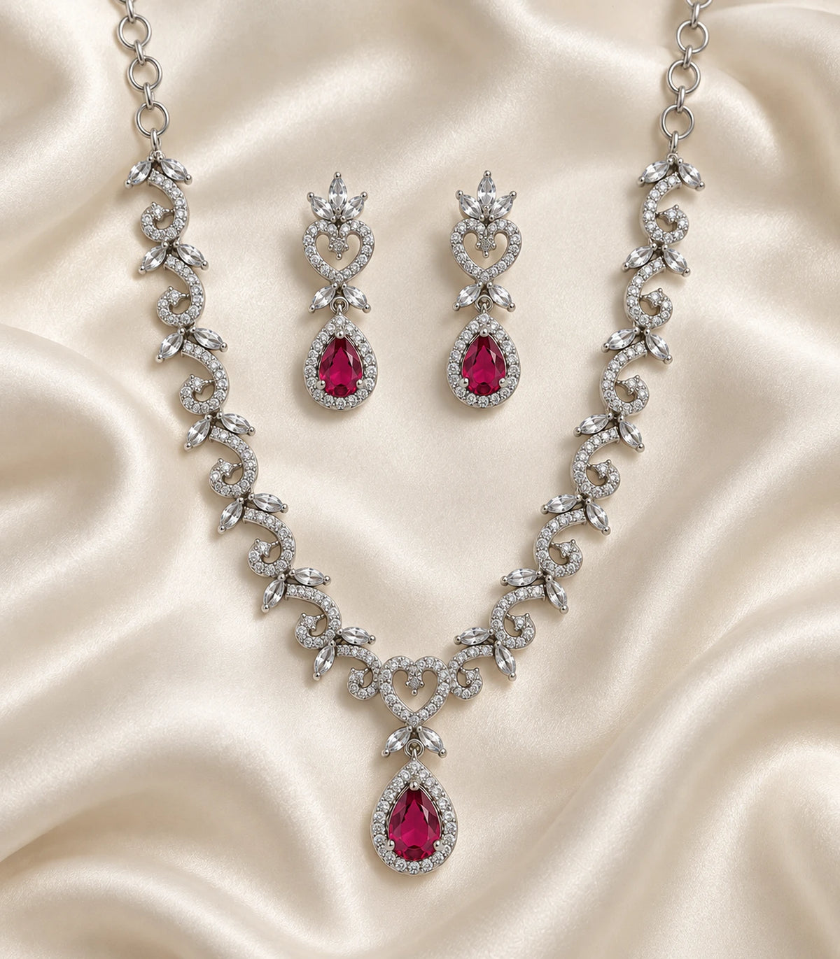 Silver magenta heart teardrop necklace and earring pair on ivory fabric