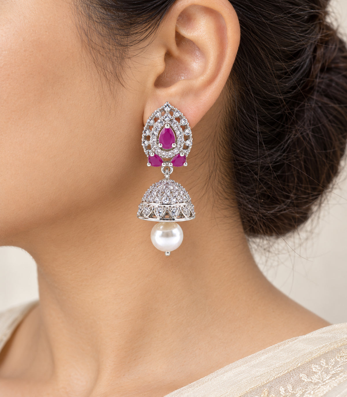Close-up of the magenta teardrop lattice top, clear-stone bell and white pearl-style drop worn at the ear