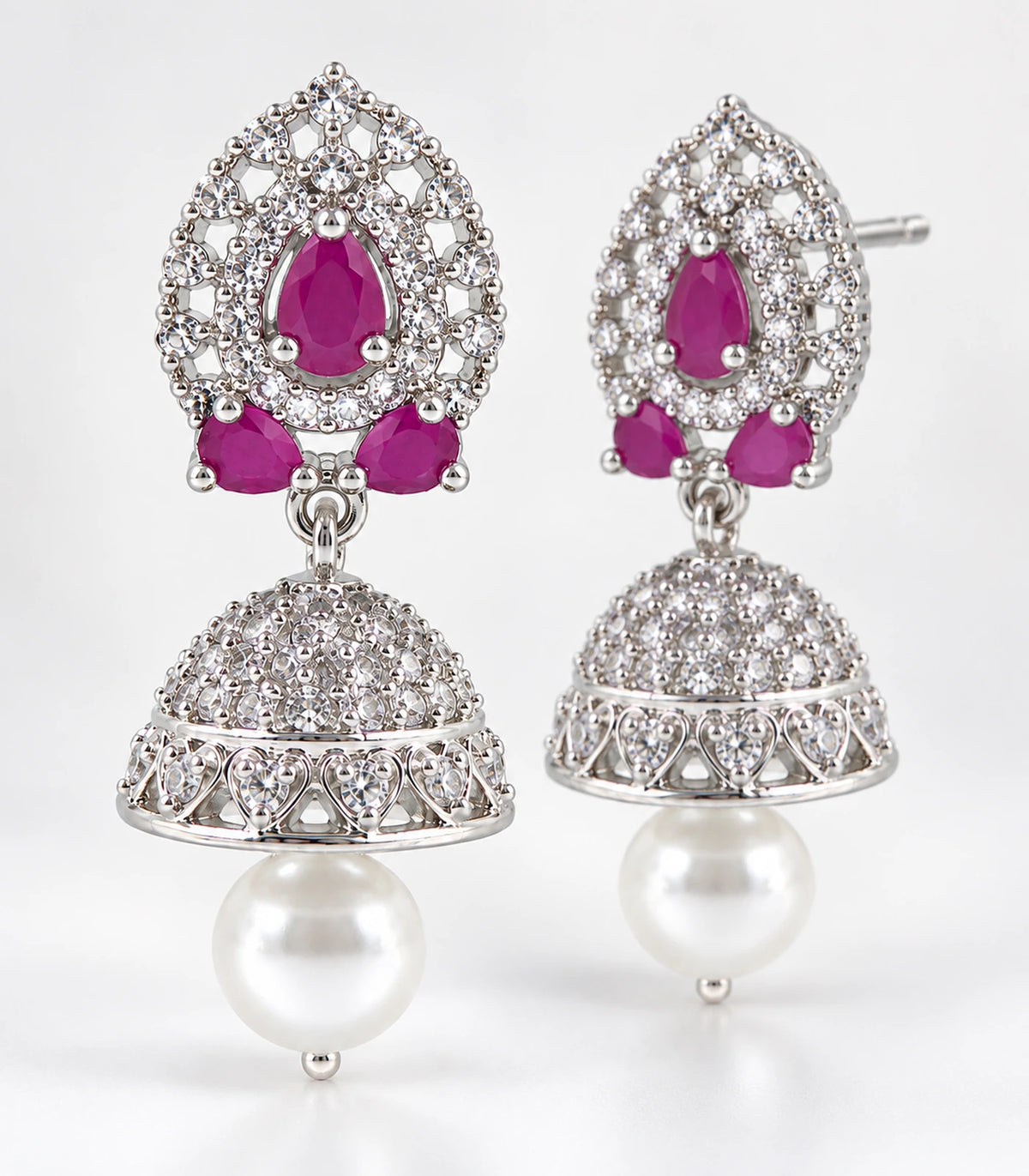 Matching magenta lattice jhumka earring pair showing silver-tone heart-shaped bell rim settings