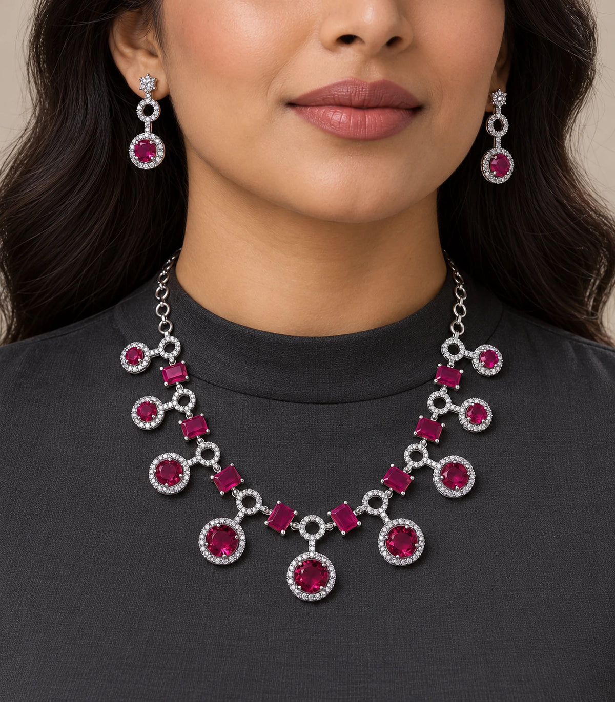 Silver-tone magenta necklace set and matching drop earrings worn with a dark top