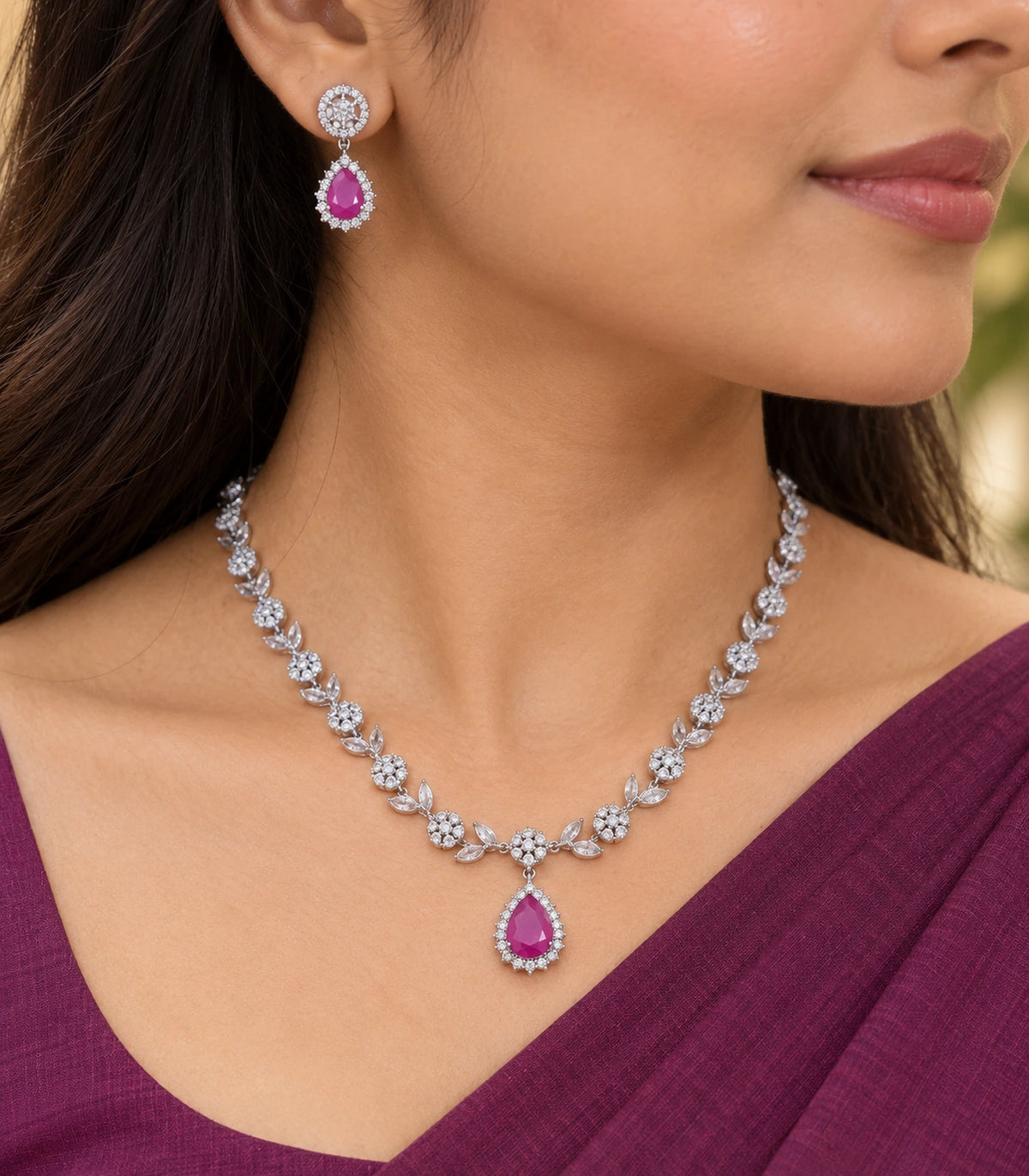 Close view of the magenta teardrop earring and matching necklace worn together