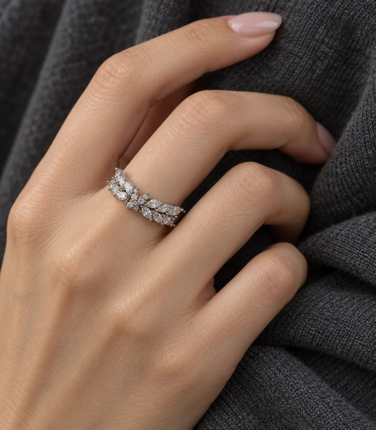 Silver marquise leaf wing open ring worn on a bent hand against dark clothing