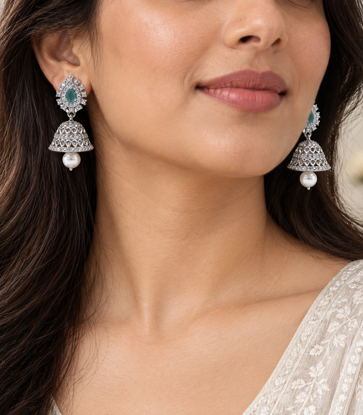 Close view of matching mint teardrop jhumka earrings worn with pearl-look drops