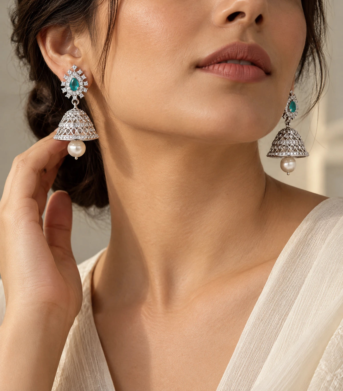 Editorial worn view of matching mint teardrop silver-tone jhumka earrings with pearl-look drops