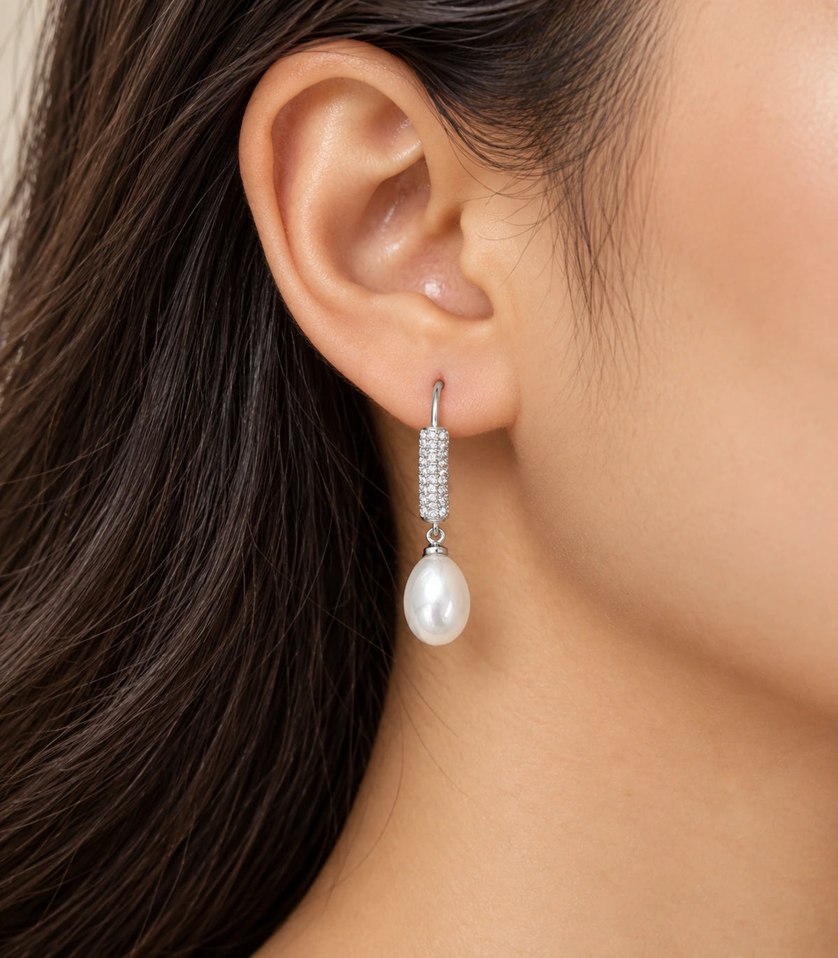 Editorial worn view of the silver-tone pavé bar earring and white teardrop pearl-style drop