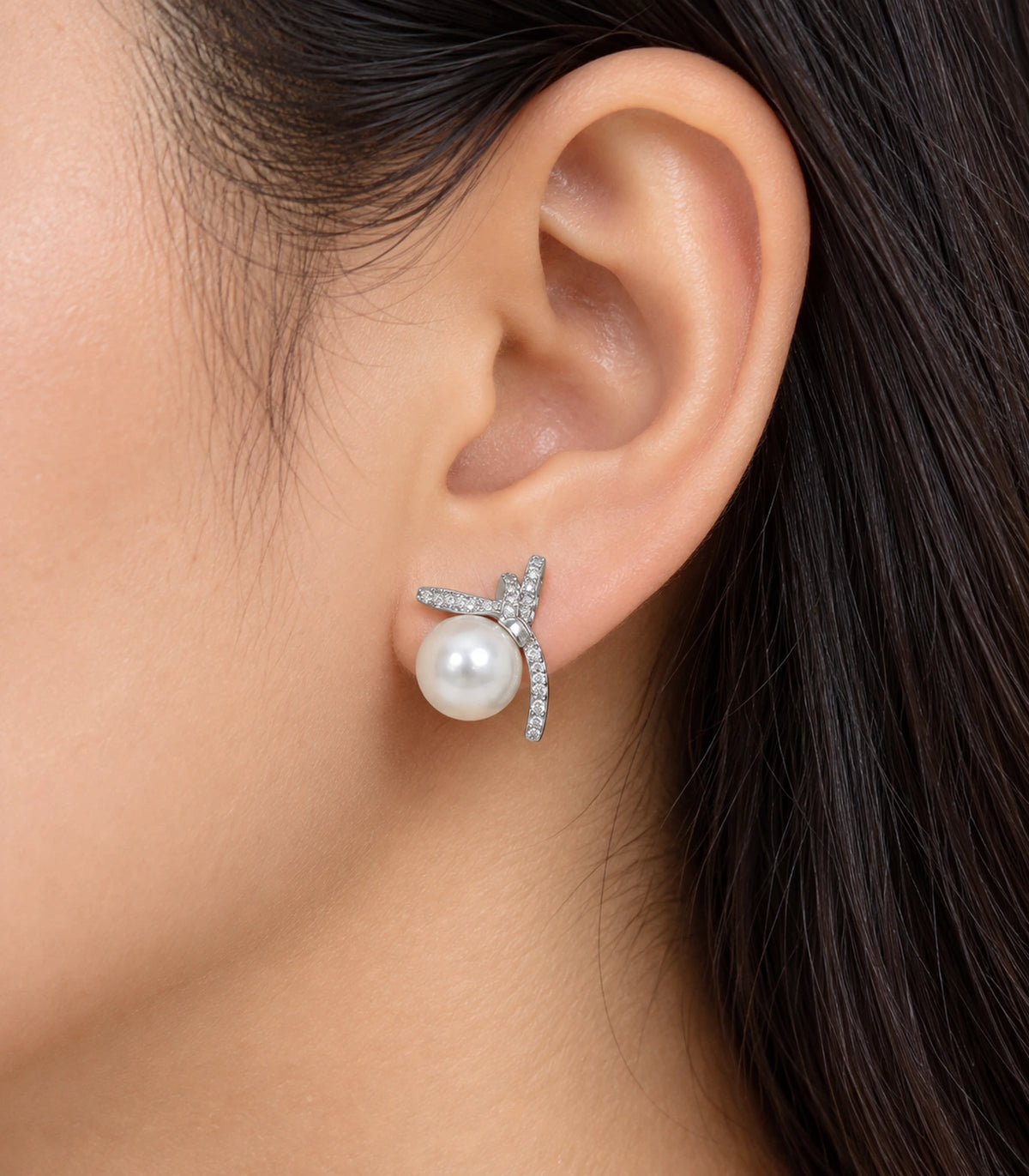 Silver-tone pavé star pearl-look stud earring worn on one ear