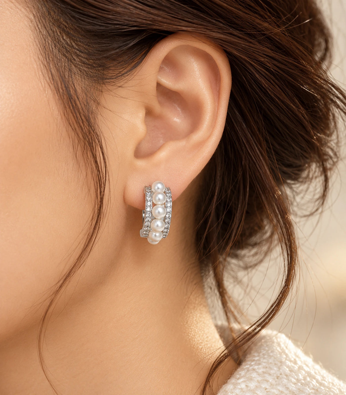 Silver-tone pearl and pavé triple-row huggie earring worn with an updo