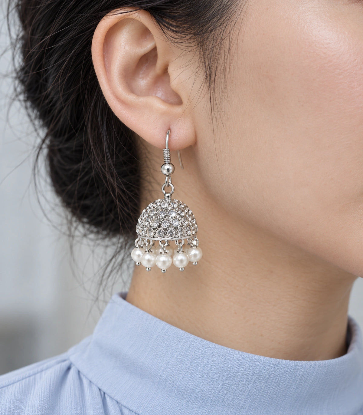 Close-up of round clear accents and white pearl-effect drops on a silver-tone jhumka #color_silver
