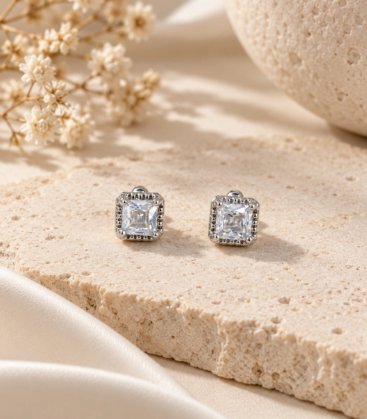 JIMIKI Silver Square Halo Crystal Stud Earrings in Silver - editorial flatlay #color_silver