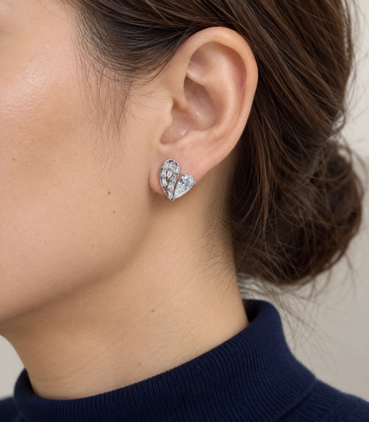 JIMIKI Asymmetric Crystal Heart Stud Earring Pair in Silver Tone, model wearing view #color_silver tone
