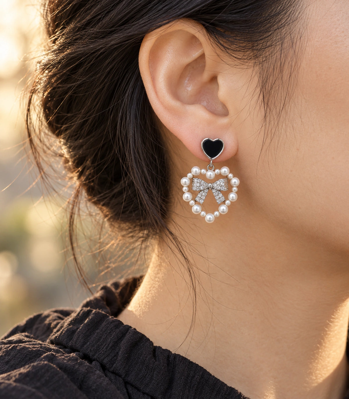 JIMIKI Heart Pearl Bow Drop Earring Pair in Silver Tone / Black, editorial model view #color_silver tone / black