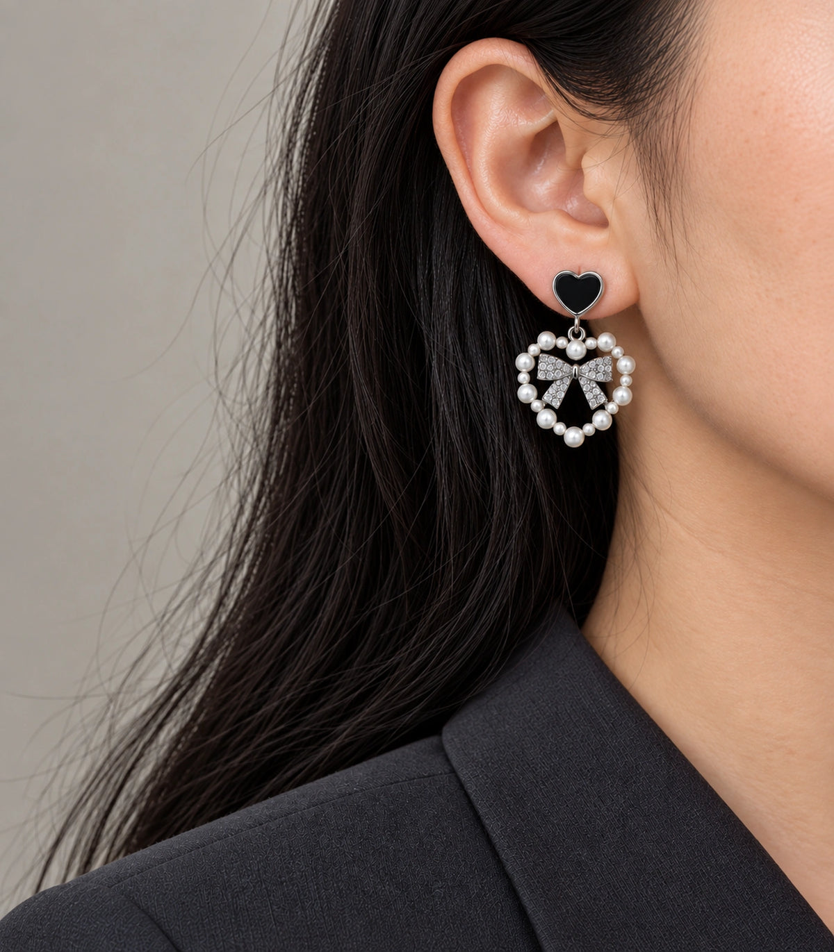 JIMIKI Heart Pearl Bow Drop Earring Pair in Silver Tone / Black, model wearing view #color_silver tone / black