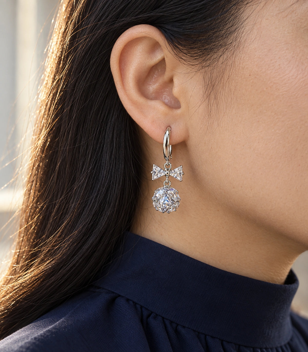 JIMIKI Silver Tone Clear Crystal Bow Cluster Ball Hoop Earring Pair in Silver tone / clear, editorial model view