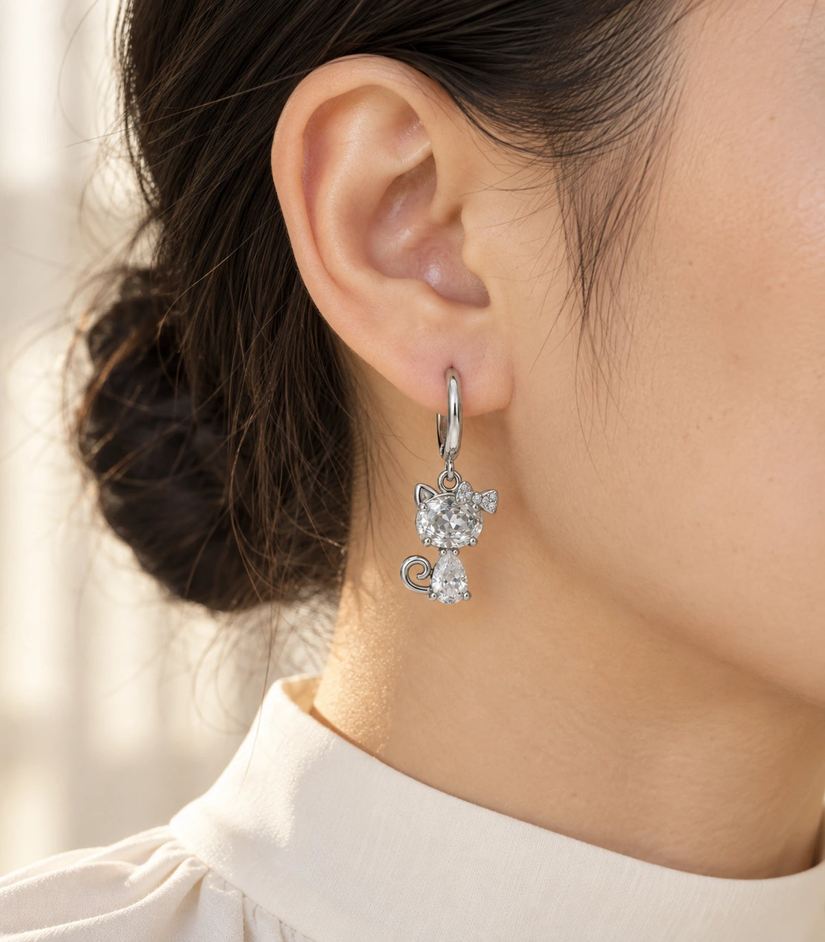 JIMIKI Silver Tone Clear Crystal Cat Bow Hoop Earring Pair in Silver tone / clear, editorial model view