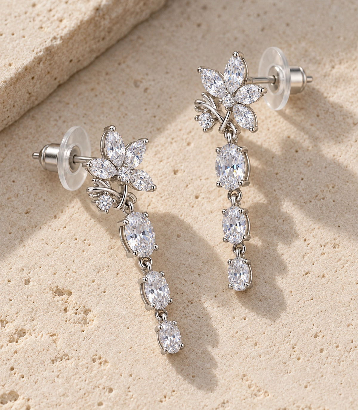JIMIKI Floral Triple Oval Drop Earring Pair in Silver tone / clear, editorial flat lay #color_silver tone / clear