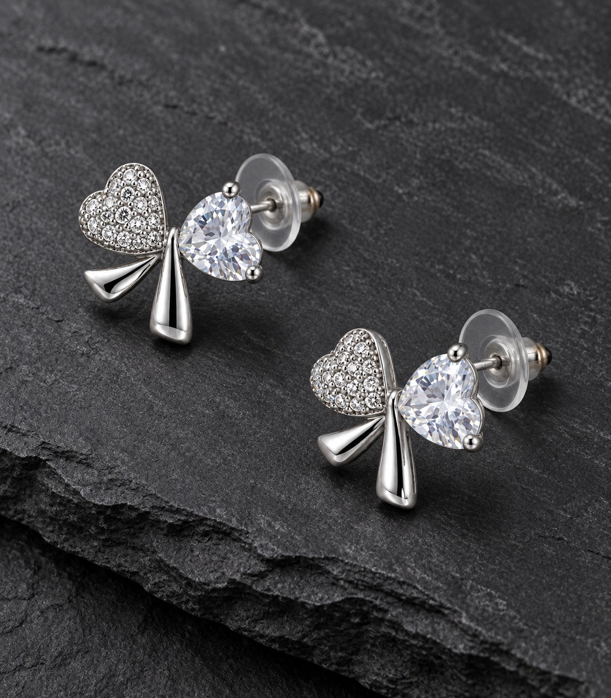 JIMIKI Silver Tone Clear Heart Bow Stud Earring Pair in Silver tone, editorial flat lay