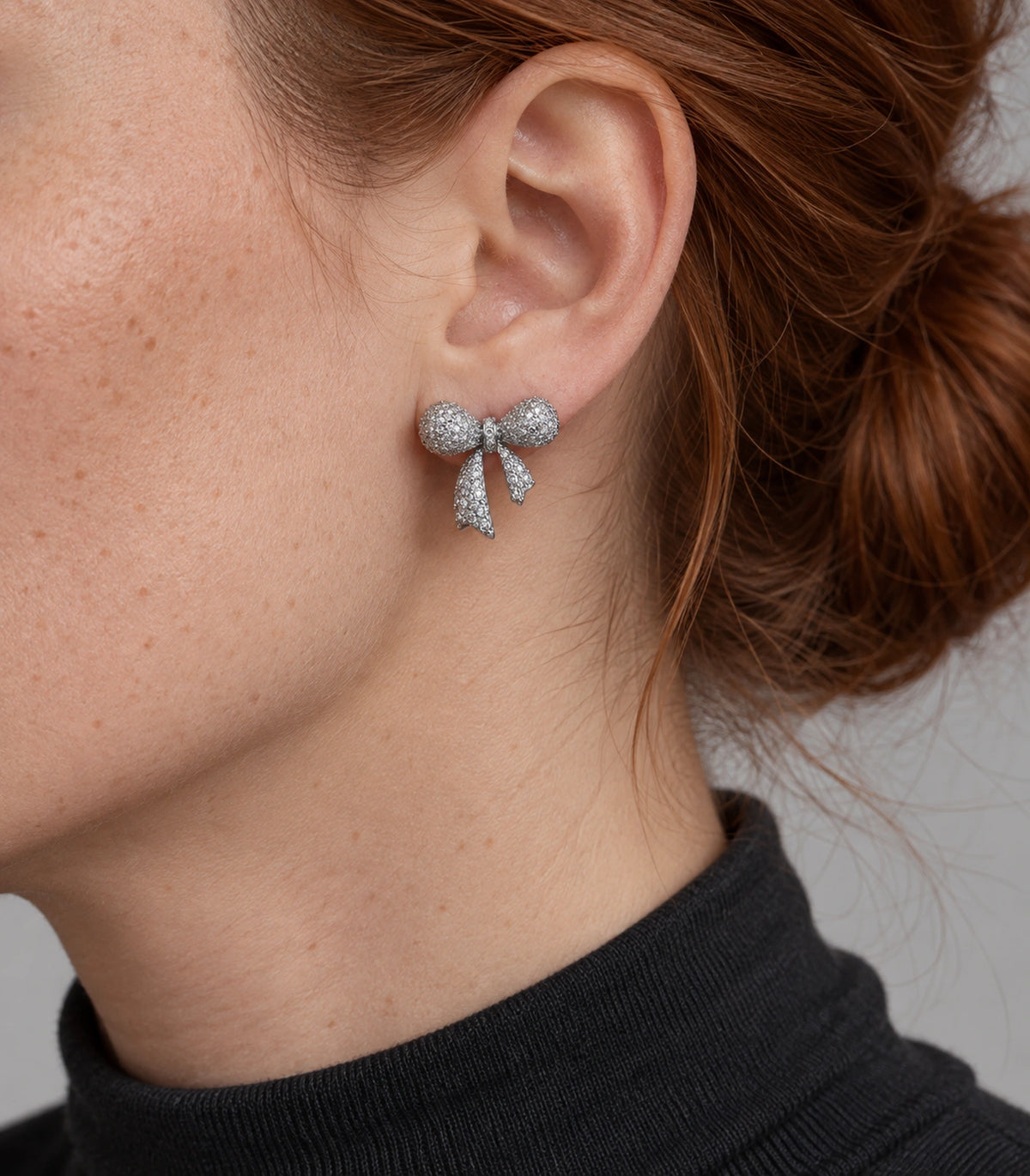 JIMIKI Pave Ribbon Bow Stud Earring Pair in Silver-tone, model wearing view #color_silver-tone