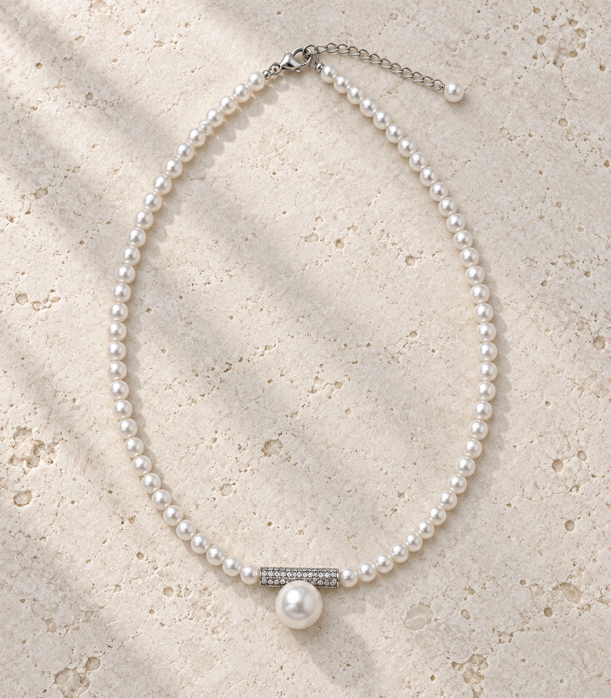 JIMIKI Silver Tone Crystal Bar Pearl Drop Necklace in Silver / White, editorial flat lay