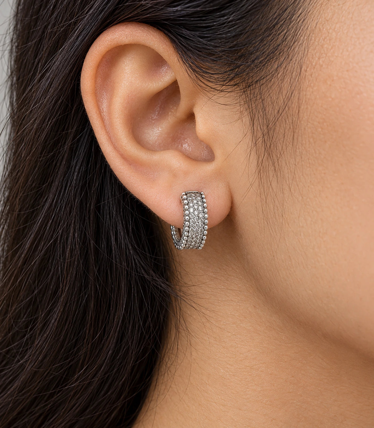 JIMIKI Silver Crystal Bead Border Huggie Hoop Earrings, worn closeup showing front details #color_silver