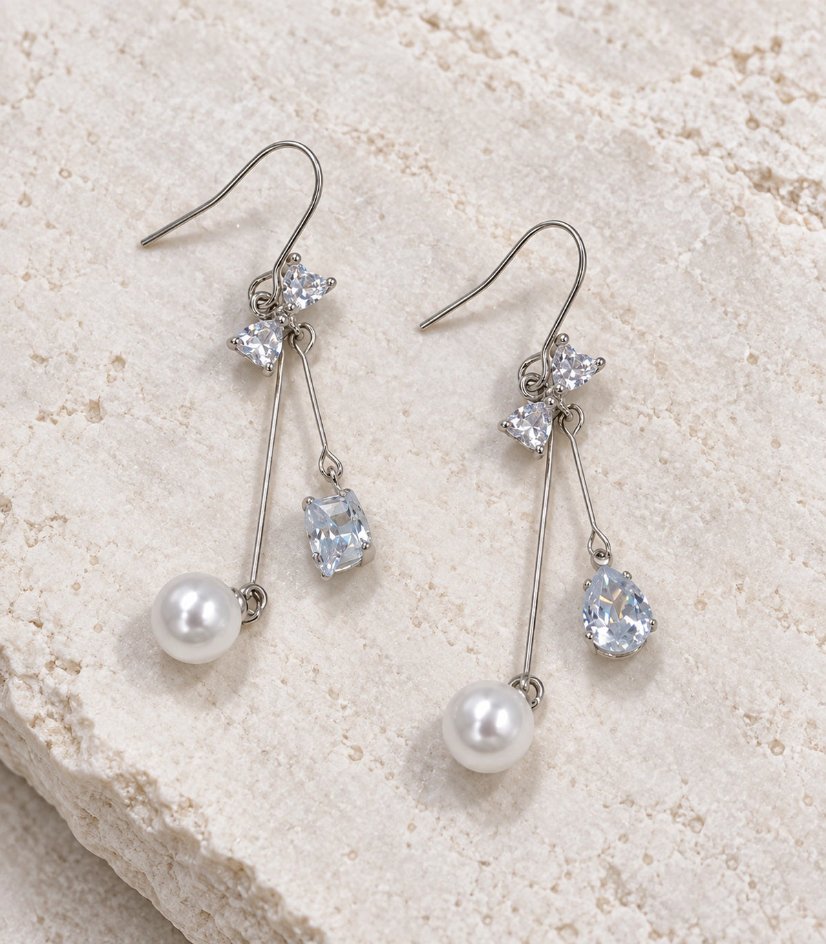 JIMIKI Silver Tone Crystal Bow Pear Pearl Wire Drop Earring Pair in Silver-tone, editorial flat lay