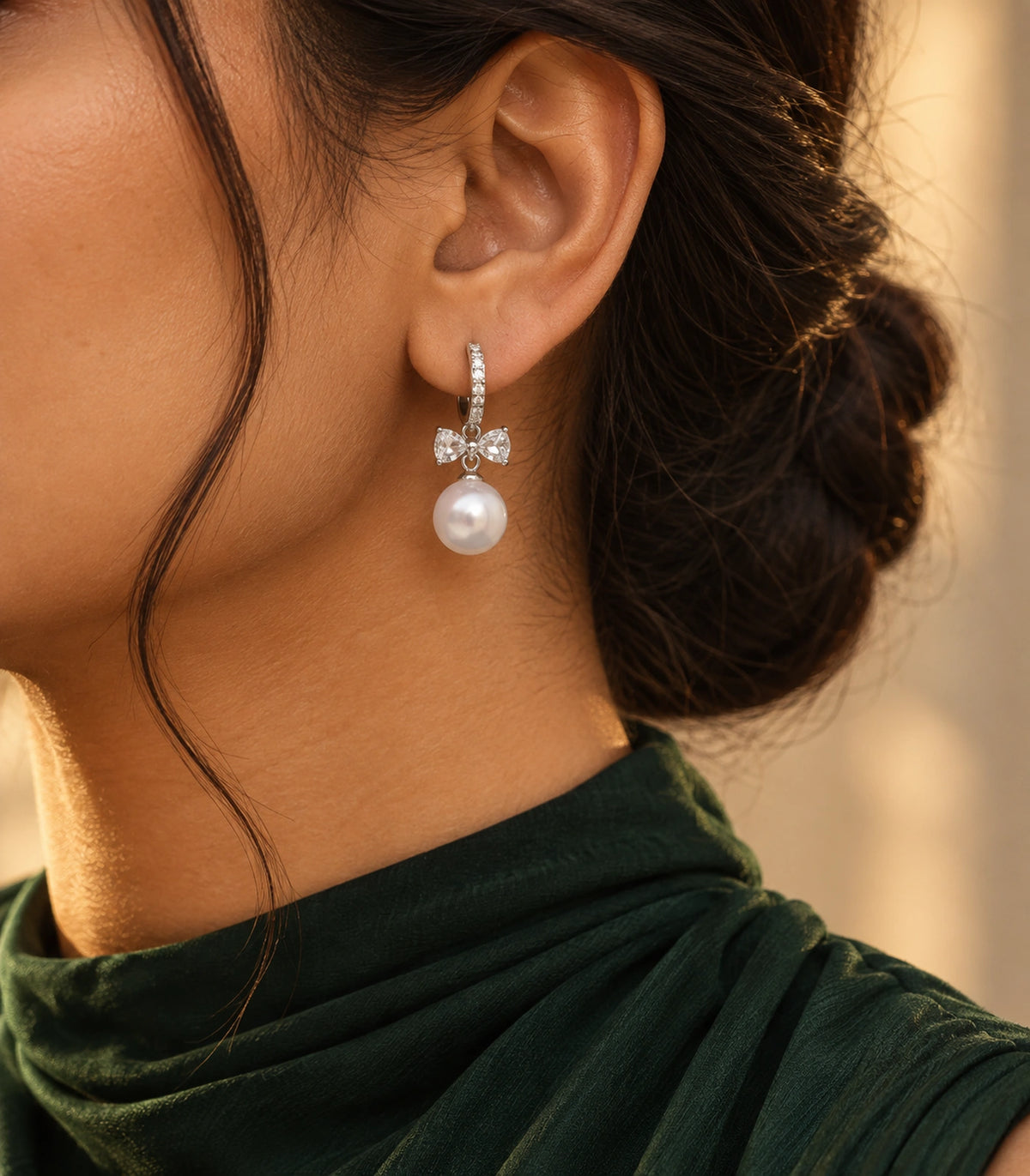 JIMIKI Silver-Tone Crystal Bow Pearl-Drop Huggie Earrings in Silver / Clear / White, editorial model view