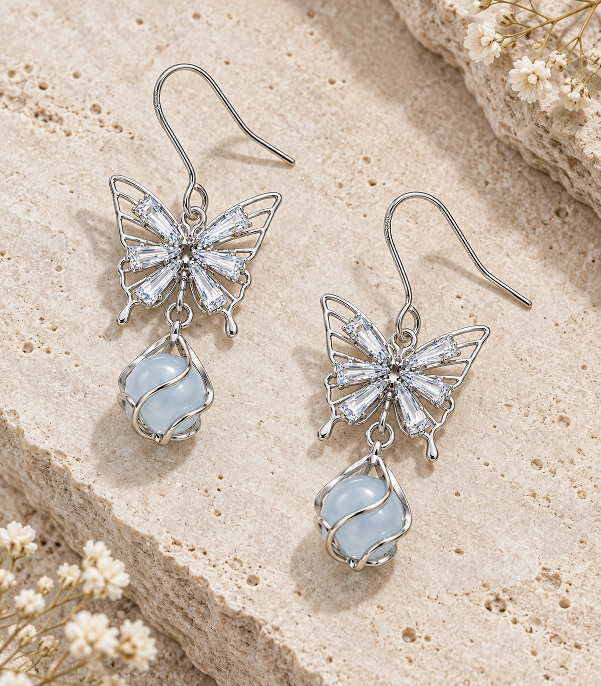 JIMIKI Silver Tone Crystal Butterfly Blue Bead Drop Earring Pair in Silver tone, editorial flat lay
