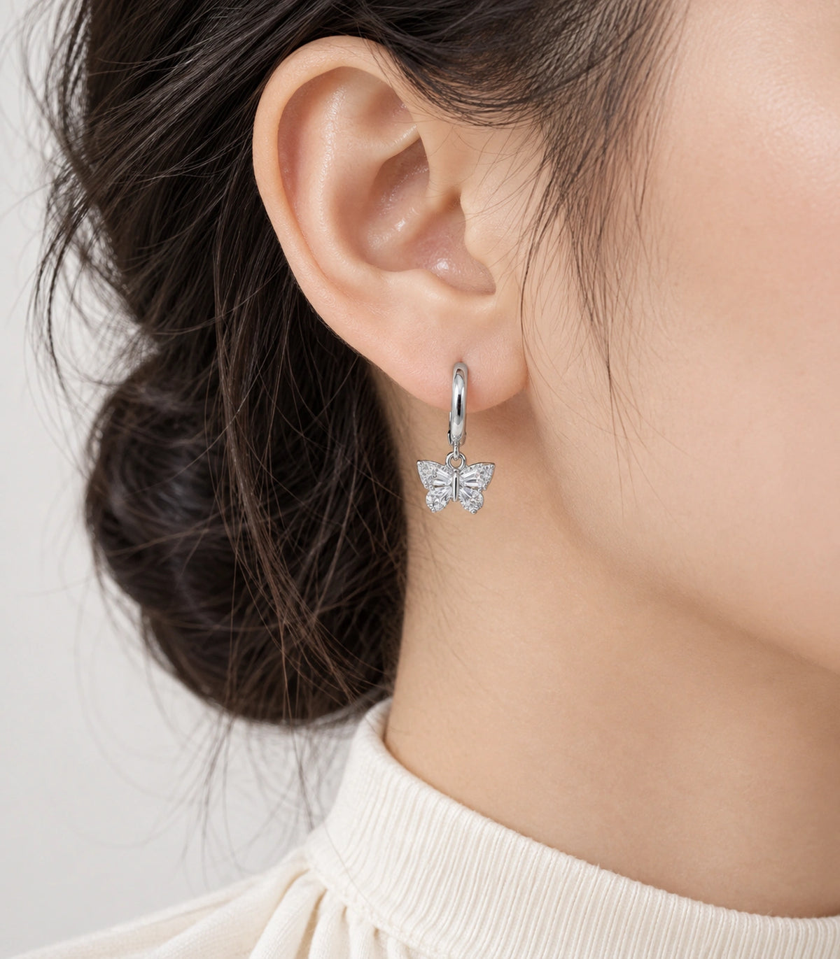 JIMIKI Crystal Butterfly Huggie Earrings in Silver / Clear, model wearing view #color_silver / clear