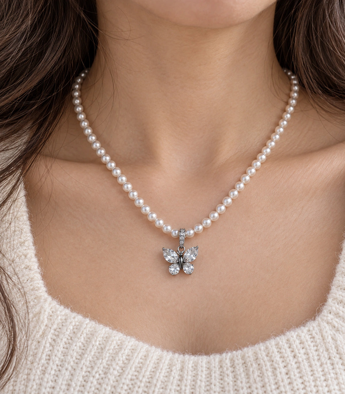 JIMIKI Silver-Tone Crystal Butterfly Pearl Necklace in Silver-tone / clear / white, close-up of the pendant and pearl-style strand